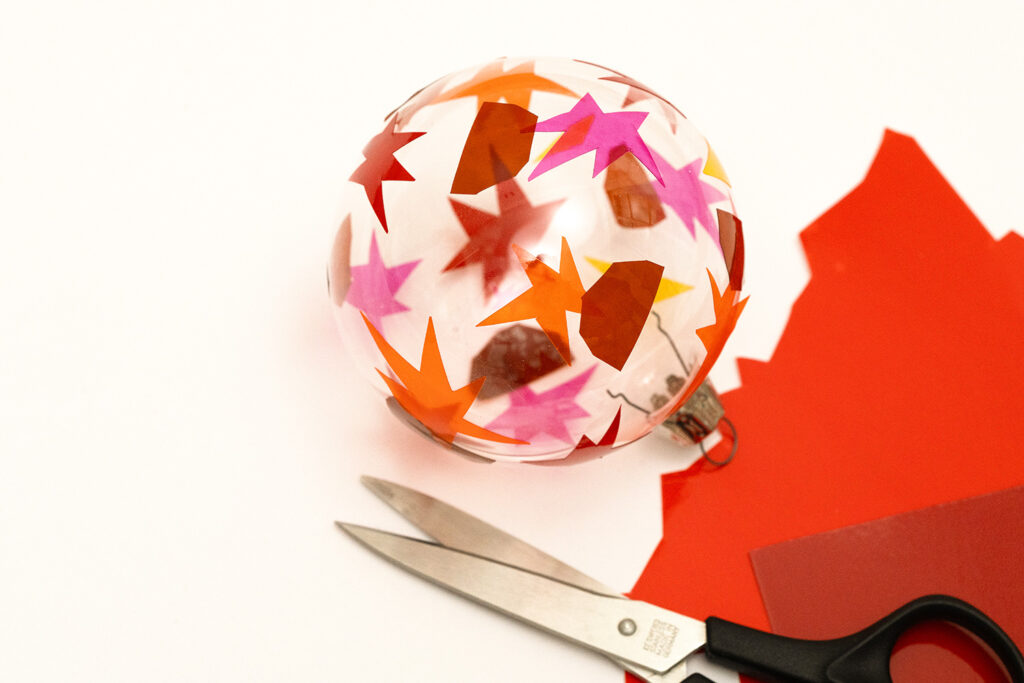 Lass uns als Baumschmuck Glaskugeln mit Fensterfolie dekorieren.