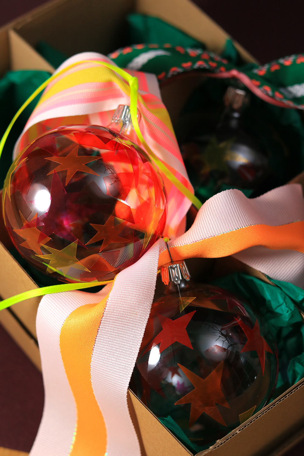 Lass uns als Baumschmuck Glaskugeln mit Fensterfolie dekorieren.