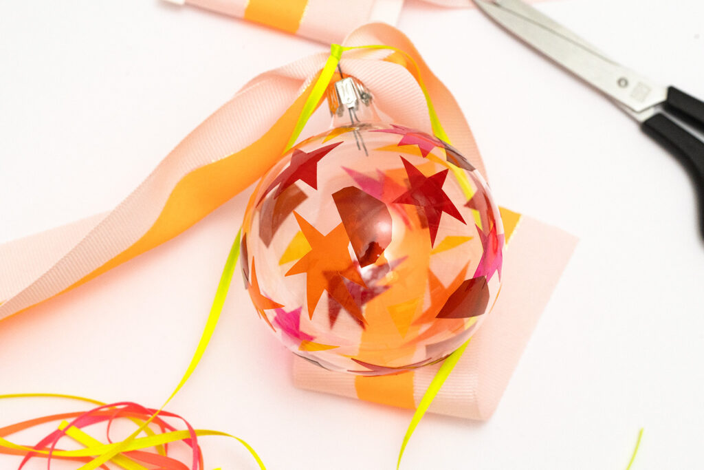 Lass uns als Baumschmuck Glaskugeln mit Fensterfolie dekorieren.
